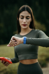 Latina woman uses her smartwatch to optimize her jogging experience on hilly terrain