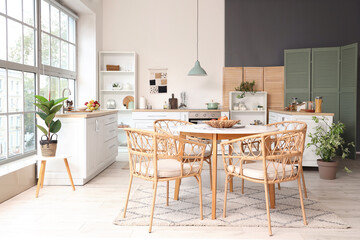Interior of kitchen with dining table, counters and houseplants