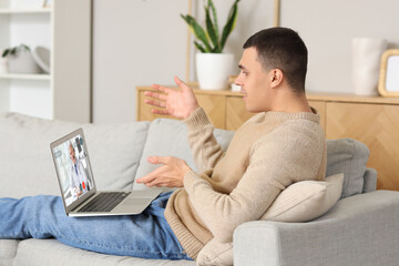 Ill young man video chatting with doctor at home