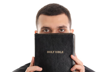 Young priest with Holy Bible on white background, closeup