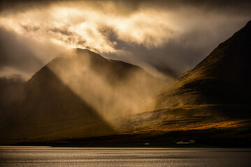 Dramatic morning light filtering through the clouds in Dyrafjördur, Westfjords, Iceland. - obrazy, fototapety, plakaty