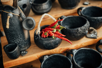 chili peppers in handcraft black clay pot
