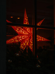 Burning Christmas star on windowsill