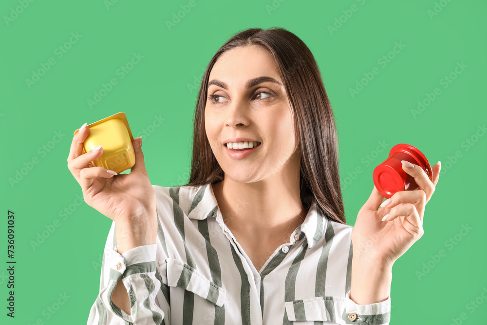 Wall mural Young woman with tasty yoghurt on green background, closeup