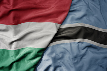 big waving national colorful flag of botswana and national flag of hungary .