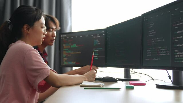Back end software developer engineer for computer programming working together on debugging writing computing code, solving complex algorithms display on monitor in office. Burgeoning