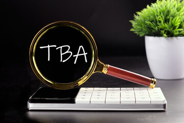 TBA text seen with a magnifying glass on a black background