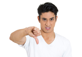 Closeup portrait of angry, unhappy, young handsome man showing thumbs down sign, in disapproval of...