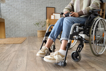 Young woman in wheelchair playing video game at home