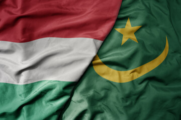 big waving national colorful flag of mauritania and national flag of hungary .