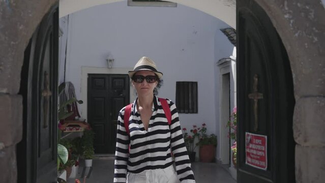 Woman tourists visiting a famous landmark of Vlacherna Monastery in Kanoni area of Kerkyra town, Corfu Island, Greece, slow motion