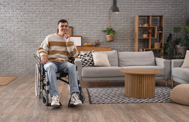 Happy young man in wheelchair at home