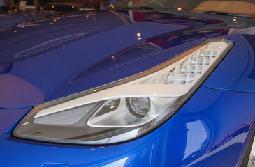 Predatory car headlight and hood of powerful sports car with matte paint.