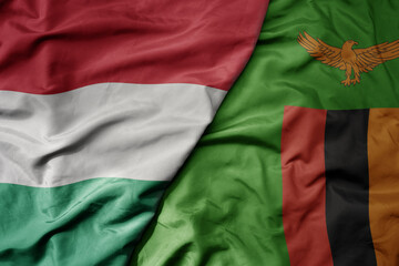 big waving national colorful flag of zambia and national flag of hungary .