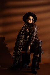 Fashionable confident woman wearing hat, sunglasses, trendy long faux fur leopard print coat,...