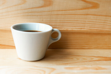 Obraz na płótnie Canvas White coffee cup on wooden background