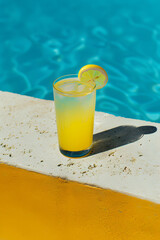 Crystal clear blue water in the swimming pool and orange juice as refreshment. Summer vacation wallpaper