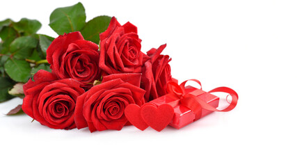 Red rose bouquet with gift box and red felt hearts on white background. Soft focus. Greeting card. Copy space for text