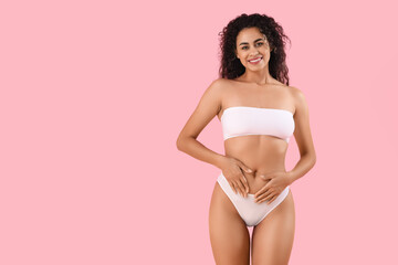 Fototapeta na wymiar Beautiful young happy African-American woman with stretch marks on her body against pink background