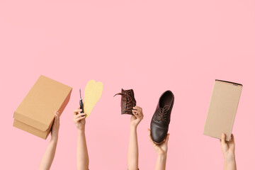 Female hands with stylish shoe, boxes and insoles on pink background. Shoes repair concept