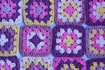 Handmade crocheted zigzag ornaments on grey background with copy space. Colorful cotton granny...
