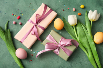 Easter eggs with gift boxes and tulip flowers on green grunge background