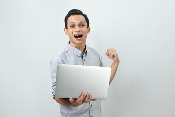 happy asian indonesian man holding laptop computer on isolated background