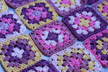 Handmade crocheted zigzag ornaments on grey background with copy space. Colorful cotton granny...