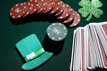 Poker chips, cards, leprechaun's hat and lucky clover on dark green background. St. Patrick's Day...