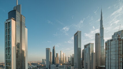Aerial sunrise view of Dubai Downtown skyline with many towers night to day timelapse.