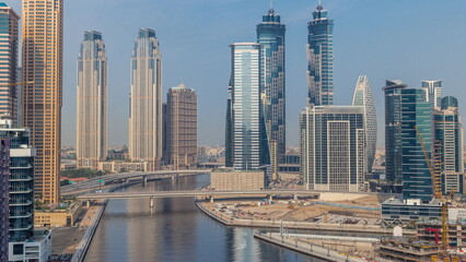 Fototapeta na wymiar Cityscape with skyscrapers of Dubai Business Bay and water canal aerial morning timelapse.