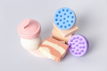 Hair scalp massagers with shampoo bars and stands on grey background