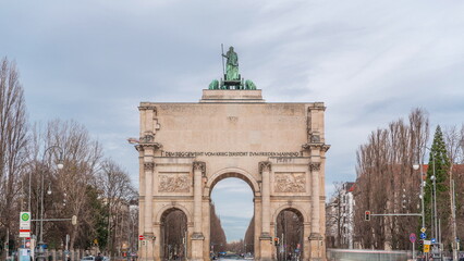 Fototapeta na wymiar The Siegestor or Victory Gate in Munich is a memorial arch, crowned with a statue of Bavaria with a lion quadriga timelapse. Germany