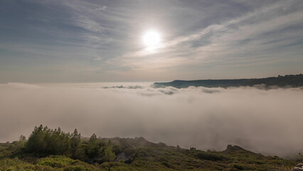 Obraz premium Panorama showing aerial View of Sesimbra Town and Port covered by fog timelapse, Portugal.