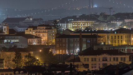 Fototapeta na wymiar Aerial view towards Barrio Alto and 25th of April Bridge night timelapse, Lisbon, Portugal.