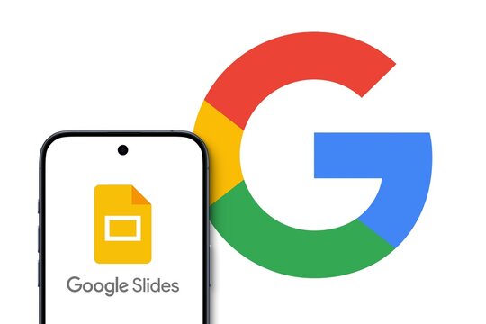 Google Slides Logo shown on a modern smartphone, big Google logo in the background, presentation program included as part of the free, web-based Google Docs suite offered by Google., Alphabet