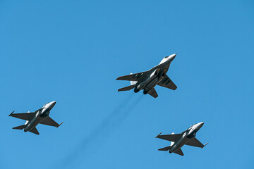 Military air force fighter jet interceptor airplane in full flight against the blue sky