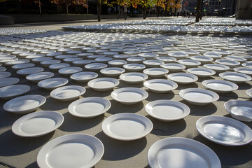 Public installation of empty plates symbolizing hunger - encouraging reflection and action among passersby.