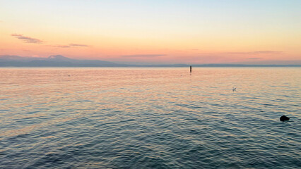 Sunset view of the beautiful Lake Garda. Sirimione, Italy. Mobile photo, copy space.