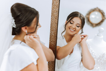 In the morning, an incredibly beautiful and luxurious bride, dressed in a white robe, poses by the...
