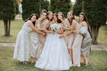 Wedding photography. A brunette bride in a white dress with a bouquet and her brunette girlfriends