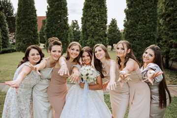 Wedding photography. A brunette bride in a white dress with a bouquet and her brunette girlfriends