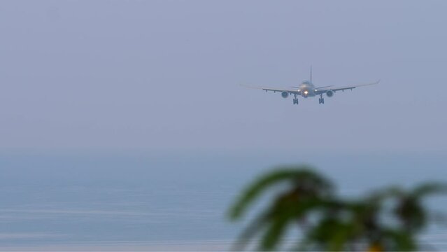 Passenger plane approaching landing, front view. Sea background. Airfield on the coast of the island