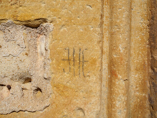 Stonemason mark carved on the facade of Nuestra Señora de la Concepción church. Yelo, Soria, Castilla y Leon, Spain. - 736225636