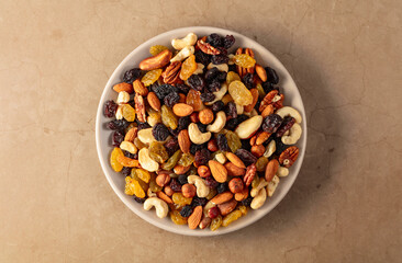 Mix of dried nuts and raisins on a stone background.