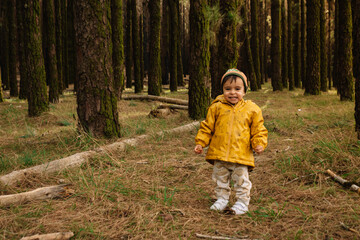 Boy laughing in the forest with a funny face and cold weather clothing