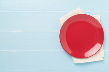Empty plate with tablecloth on wooden background, top view