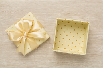 Beige open gift box on wooden background, top view