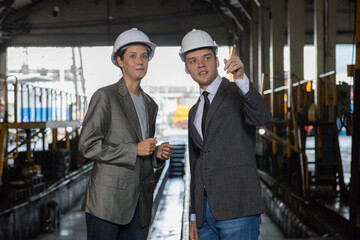 Chief engineer consults and analyzes train diesel engine problems Railway tracks in a train depot