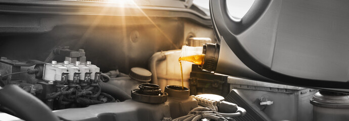Pouring motor oil into car engine, color accent effect. Banner design - obrazy, fototapety, plakaty